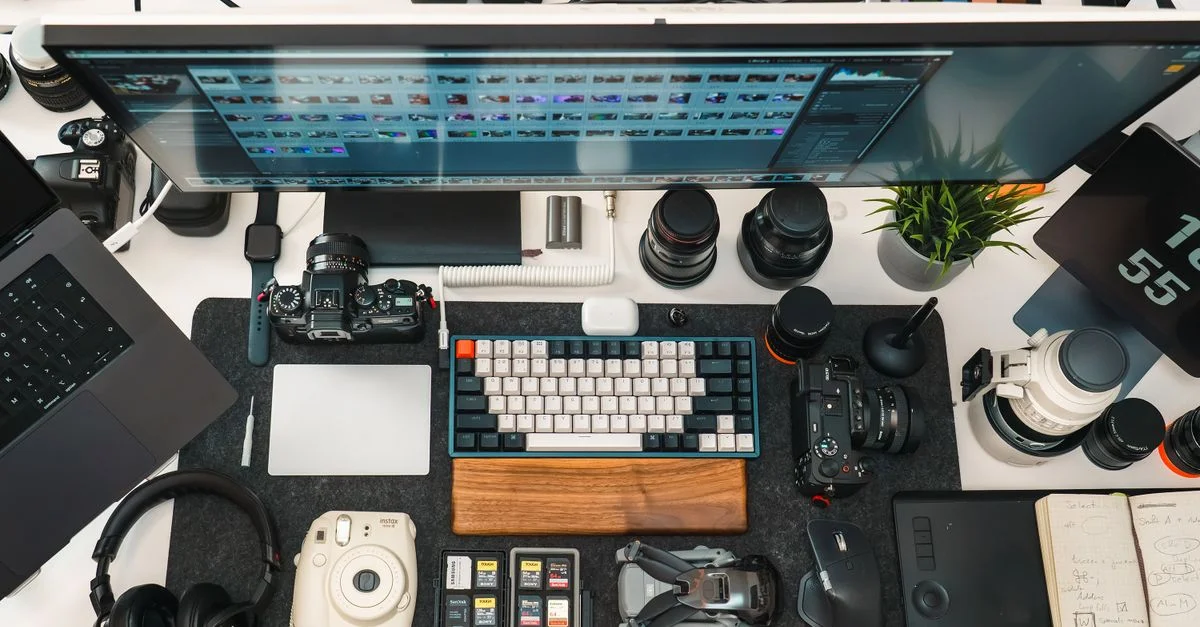 Vue à plat du bureau organisé d'un photographe, avec appareils photo, objectifs et matériel de montage.