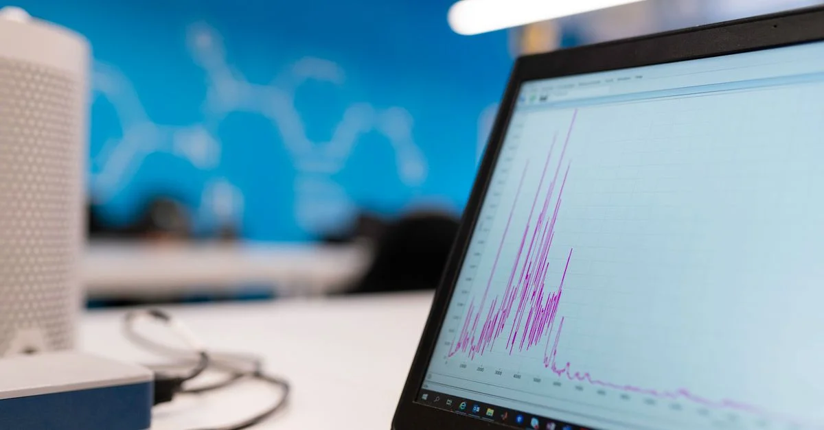 Ordinateur portable affichant un graphique d'analyse de données dans un cadre de bureau moderne, symbolisant la croissance et la technologie.